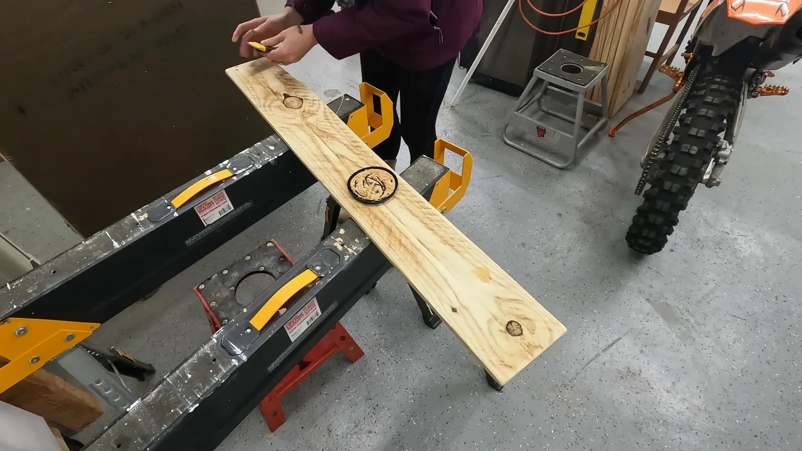 Applying Minwax stainable wood filler to nail holes on the sanded wood plank.