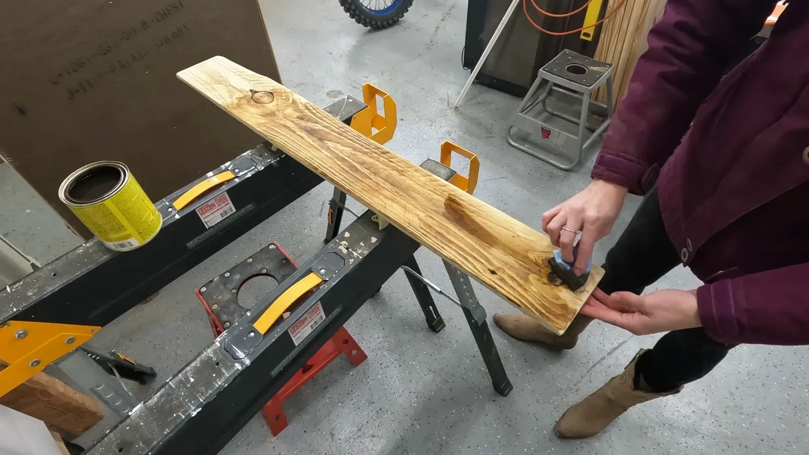 Wiping Varathane Early American wood stain onto the prepared wood plank with a lint-free cloth.