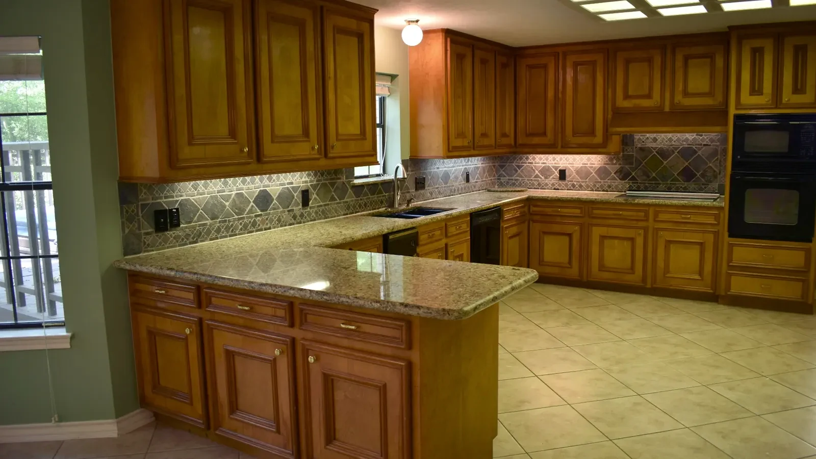Close-up of outdated 90s kitchen cabinets with a glossy wood finish.