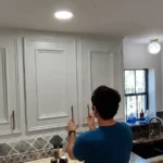 Full view of the kitchen with bright white upper cabinets and new gold hardware.