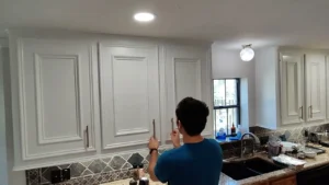 Full view of the kitchen with bright white upper cabinets and new gold hardware.