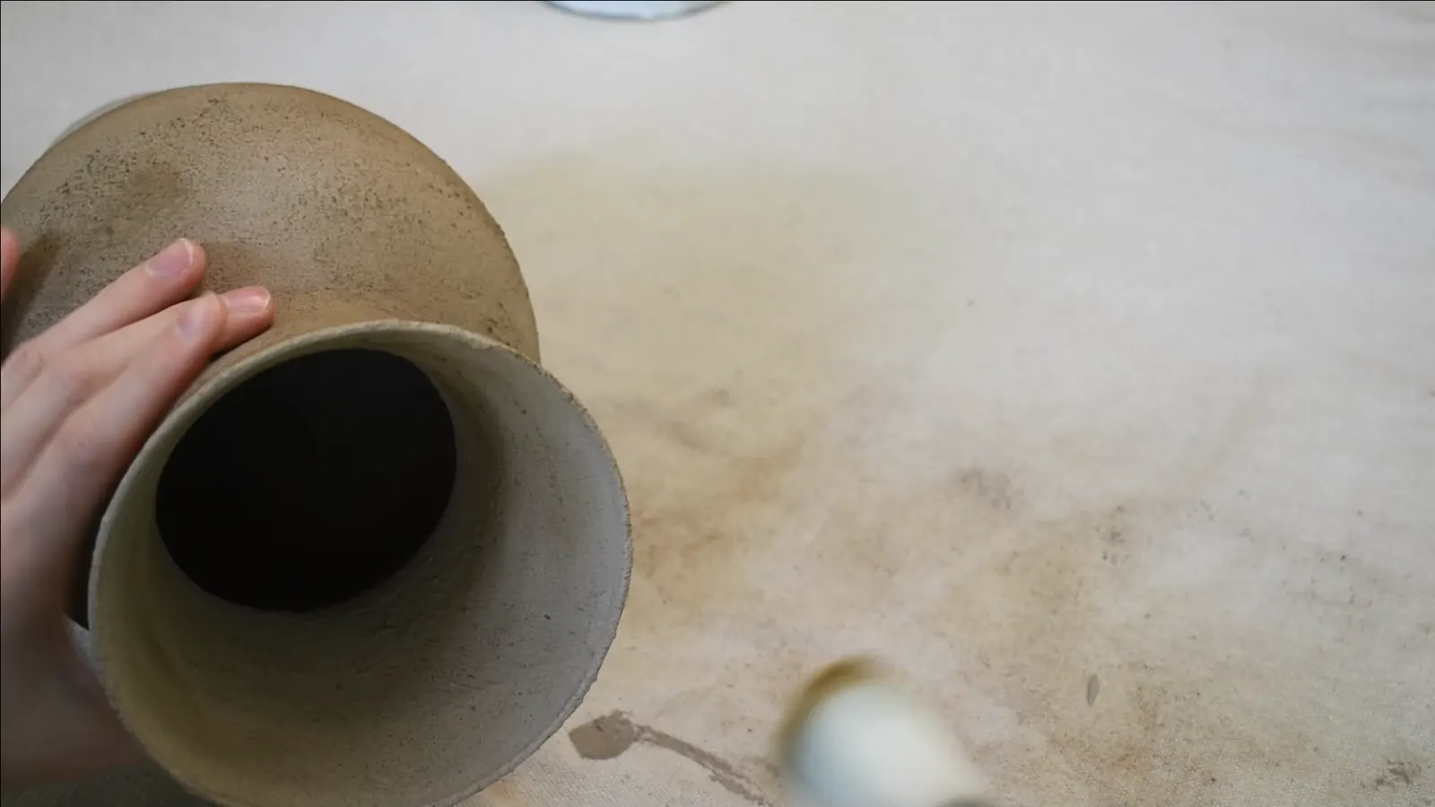 Two finished stone-look vases, one taller and one shorter, with a textured beige finish and subtle brown waxing.